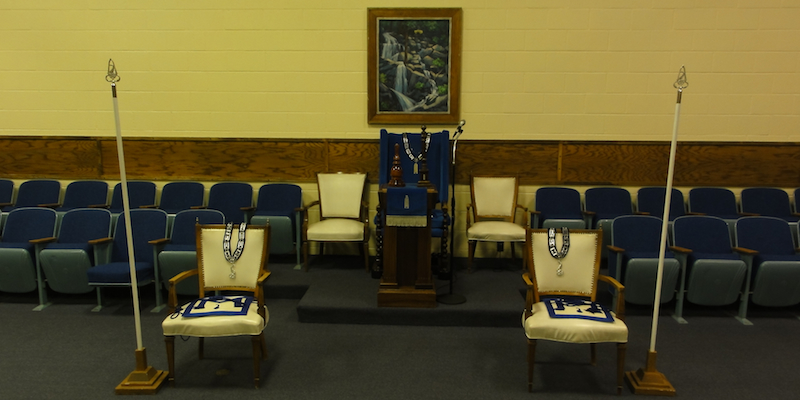 The chairs in the South, with jewels, aprons, rods, pillars, and gavel.