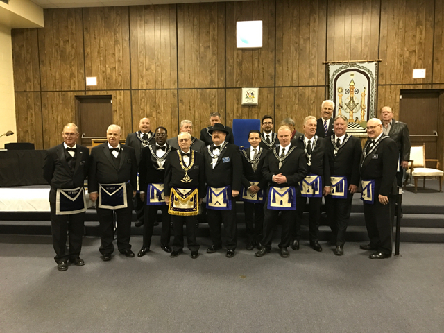All the officers lined up in front of the lodge in Masonic Regalia.