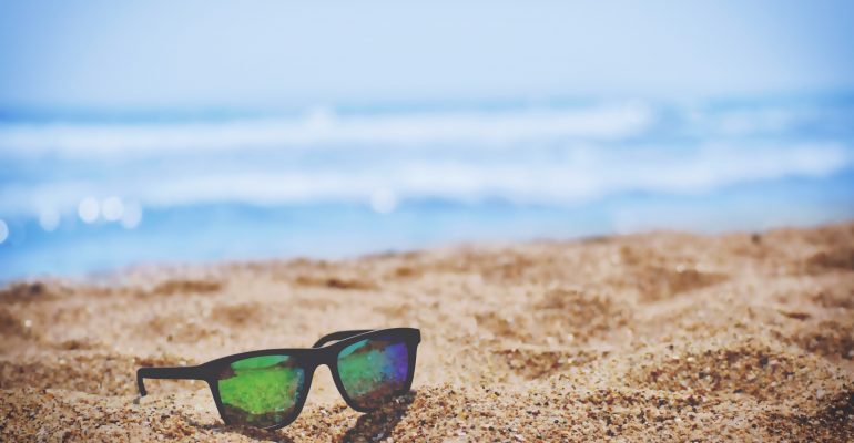 Picture of sunglasses on a beach.